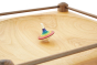 Close up of a Mader Rainbow stripe spinning toy on a Mader large wooden spinning plate