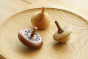 Close up of the Mader Classic, Leporello and Duet wooden spinning tops on a Mader wooden spinning plate