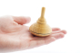 Close up of a Mader handmade classic wooden spinning top toy in the palm of a hand