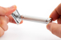 Close up of some hands holding each end of the Muhle plastic-free chrome stainless steel twist razor on a white background