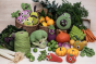 Myum handmade crochet soft vegetable toys laid out on a pile of real vegetables on a white table