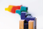 Close up of the blocks from the Naef premium campanile shape sorting puzzle toy lined up on a white background
