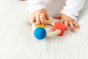 Baby reaching for the Oli & Carol X Bauhaus Movement Teething Ring with both hands