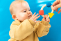 baby reaching up to hold onto the Baby clutching onto the Oli & Carol X Bauhaus Movement Teething Ring  