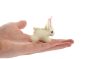 Close up of a Papoose felt baby bunny figure on the palm of a hand on a white background