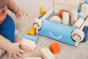 Close up of young childs hands putting toy blocks into the Plan Toys baby walker