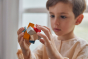 Close up of young boy looking at the PlanToys Waldorf toy block puzzle 