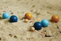 Close up of the Plan Toys plastic-free wooden petanque toy set on some sand