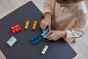 Young child grouping together pieces of the PlanToys wooden logs puzzle by colour, on a black table