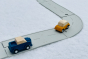 Two wooden car toys on the PlanToys rubber road and rail toy set on a white background
