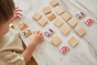 Young boy moving pieces of PlanToys animal blocks guessing game on a white table