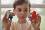 Close up of boy holding pieces of the PlanToys kids slotting block toy puzzle