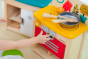 Close up of child playing with the PlanToys Wooden Play Kitchen Set. 