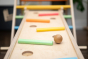 Close up of wooden balls rolling down a ball run made with the Triclimb wooden Miri slide and pastel Miri sticks