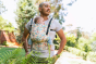 Close up of man in a garden with a baby inside a Tula soft structured FTG baby carrier