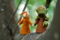 Close up of two ambrosius handmade plastic free fairy figures stood on a tree branch in the woods