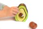 Close up of hands playing with the Bumbu plastic free wooden avocado stacking toy on a white background