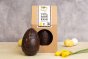 Cocoa Loco fairtrade dark chocolate easter egg on a cream worktop next to some mini easter eggs and daffodils