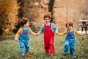 3 boys wearing the Frugi x Babipur pluto cord dungarees running through a grass field