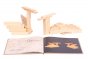 Wooden swan models next to the Kapla easy animals art book on a white background