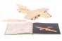 Wooden aeroplane model on a white background next to the Kapla simple architecture art book on a white background