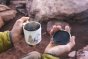 Close up of hands holding the Klean kanteen eco-friendly metal camp mug in the matte white mountain colour