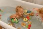 Child playing in a bath with the oli and carol natural rubber, plastic free rubber forest fruit and nut toys