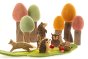 Papoose childrens handmade woodland animals toy set on a green play mat in front of some Papoose trees