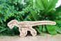 Reel wood eco-friendly wooden velociraptor toy in front of a green plant