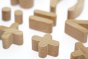 Close up of the Reel wood eco-friendly maths symbol toy blocks laid out on a white background