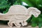 Close up of the plastic free eco-friendly reel wood spinosaurus dinosaur figure in front of a green plant