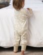 back view of toddler wearing cotton tail footless onesie with a white rabbit all-over print on pale cream and stretchy cream cuffs from piccalilly