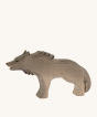 Bumbu Wooden Angry Wolf Figure, handmade and hand-painted showing the natural wood grain through out, and black painted details on the face, ears and fur. On a cream background