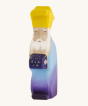 Bumbu Wooden Nativity Figure - Three Kings Melchoir on a cream background. Melchoir wears a purple and blue outfit and yellow crown, has a white beard and is holding a purple gift with gold details.