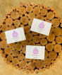 3 boxes of Kokoso Organic Baby Soap sat on top of a bundle of many cross sections of branches, different sizes