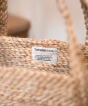 Turtle Bags Jute Basket, natural jute bag, close up of internal label, which reads: TurtleBags.co.uk Improving the lives of the marginalised communities through fair trade. Made in Bangladesh. Cream background