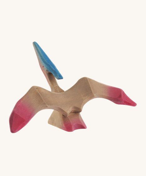 Bumbu Wooden Pteranodon Dinosaur. Hard carved to a smooth finish, and hand painted with pink wings and under the neck, on a cream background.