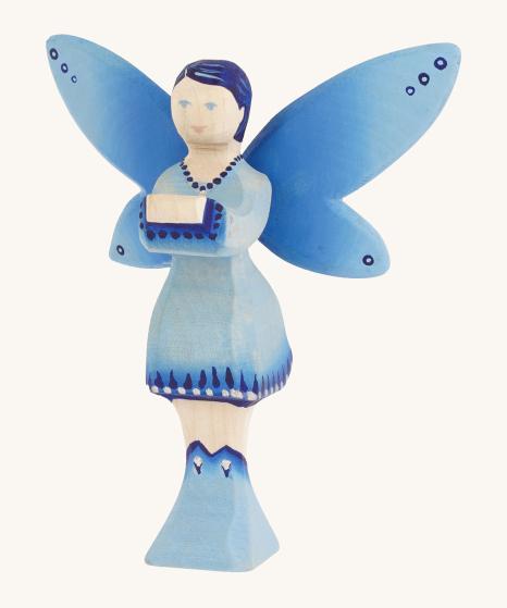 Bumbu Wooden Water Fairy Figure. The Water Fairy is coloured with hues of blue and silver on the wings, dress and boots, with inky blue hair, light blue eyes and pink lips. The Water Fairy is stood on a cream background
