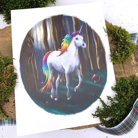 The Phive Enchanting Unicorn Print pictured on a wooden surface surrounded by moss 