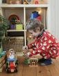 Child wearing Maxomorra Swedish Santa Pyjamas, playing with Christmas figures and toys