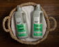 Bio-D Juniper fragranced natural, vegan friendly Laundry Liquid and Laundry Conditioner in a 1 litre bottle, in a wicker basket and laid on a white towel