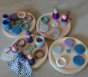 Grapat Winter Nins Seasonal Play Set, including nins, magos, rings, coins and mates in the cool, icy colours of winter. Perfect for open-ended play. Set in play spread out on natural wooden plates on a stone floor.
