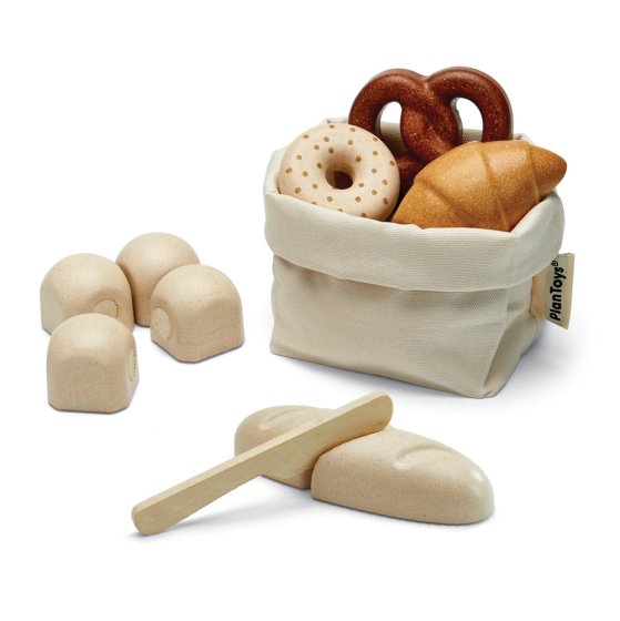 Plan toys eco-friendly wooden bread toy set in, and laid out around, its drawstring bag on a white background