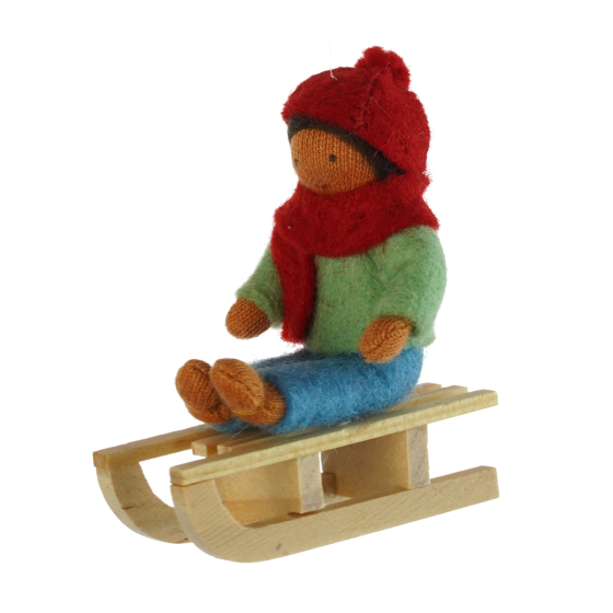 Ambrosius handmade felt boy on a sledge hanging Christmas decoration, with dark brown skin on a white background