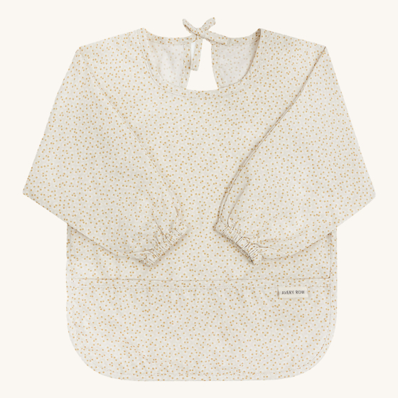 Avery Row Sleeved Bib - Daisy Meadow. A delicate daisy flower detail on a light coloured fabric, this long sleeved bib comes with a handy pocket at the front to catch food, has a tie at the back to secure the bib at the back of the neck, and elasticated s