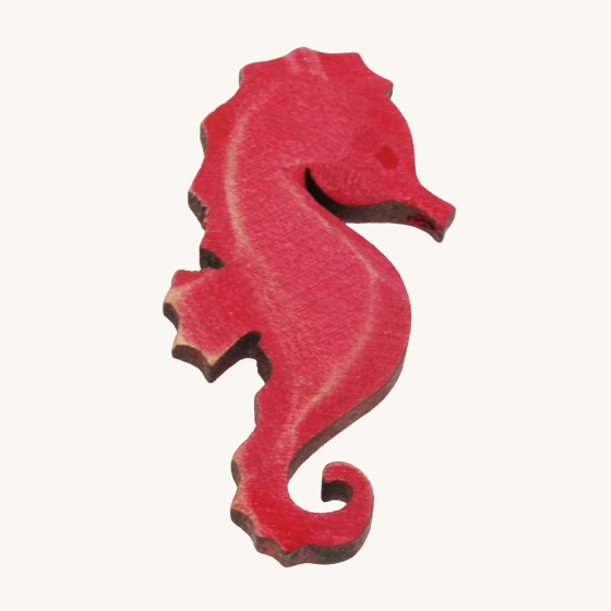 Bumbu wooden Seahorse toy figure, a bright pink wooden seahorse that has been hand crafted and hand painted, on a cream background