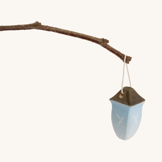 Bumbu Wooden Miniature Toy Lantern hanging from a twig, on a cream background