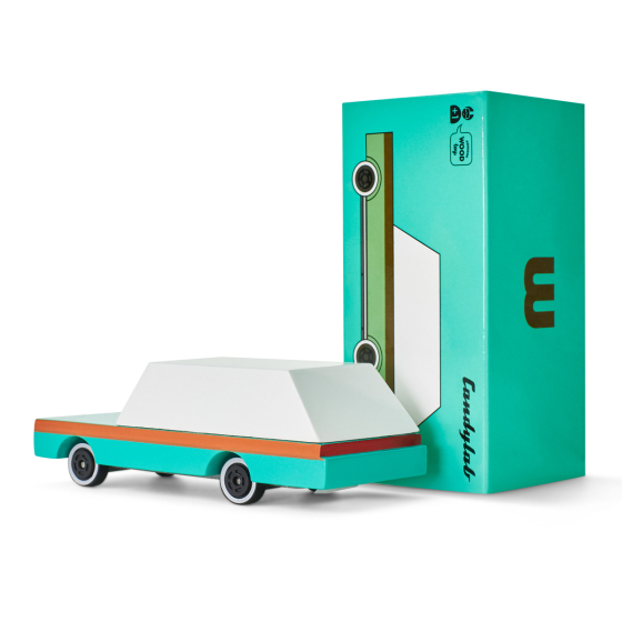 Candylab handmade wooden teal wagon toy car next to its cardboard packaging on a white background