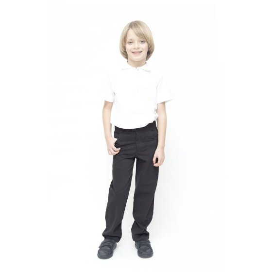 A child wearing Eco Outfitters GOTS organic cotton school uniform trousers - boys slim fit in charcoal, with a white polo shirt and black shoes, smiling with right thumb in pocket. White background