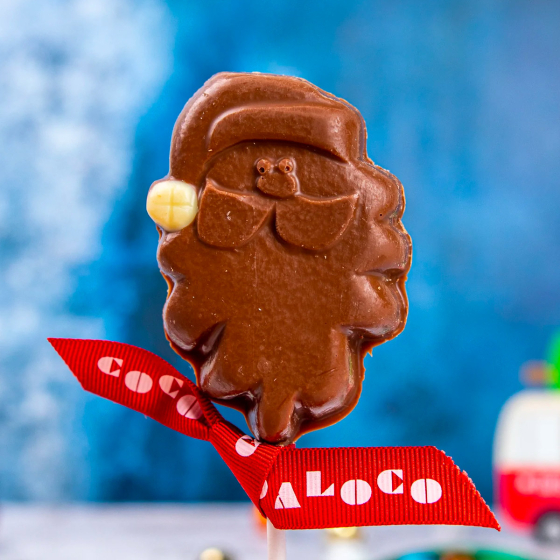 Close up of the Cocoa loco fairtrade milk chocolate santa lolly on a blue blurred background